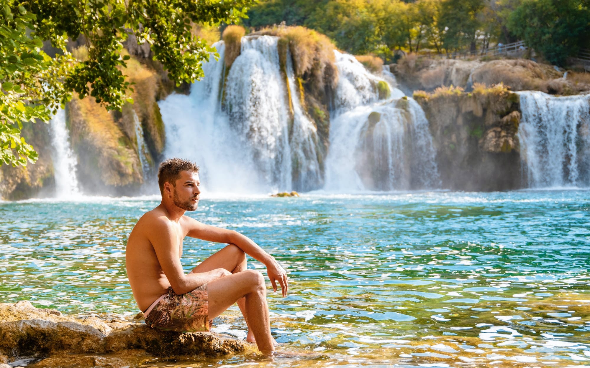 KRKA waterfalls Croatia during summer, young men sunbathing at the waterfalls of krka